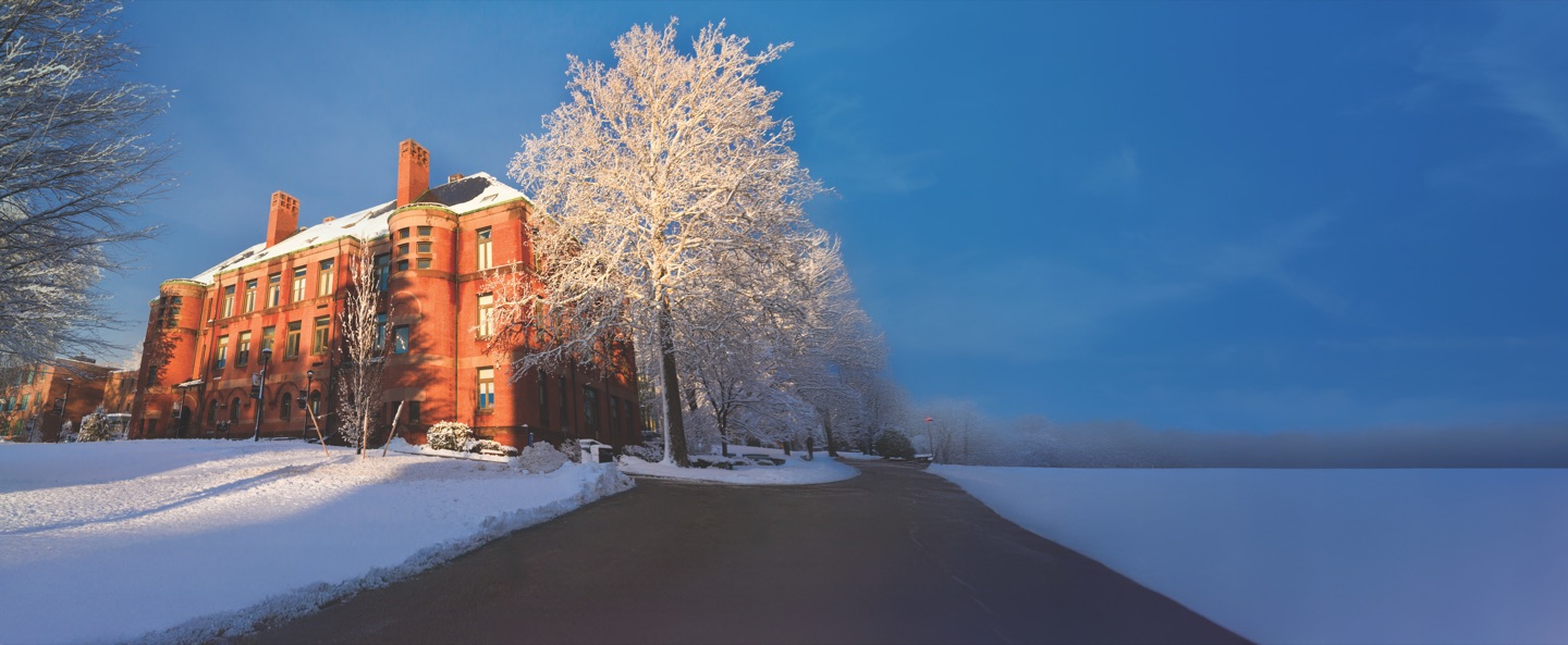 Crocker Hall, a red-brick building on the Framingham State campus, framed by snow-covered trees on a bright winter day.