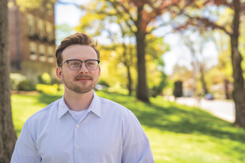 Colin McGee, an International Business graduate and Marine Corps veteran, wearing glasses and a blazer.